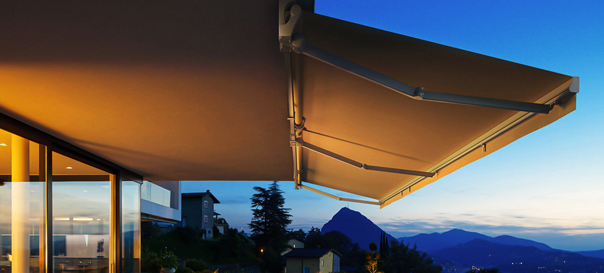 Entretien des toiles de store - Astuces pour la durabilité Store banne installé sur une terrasse avec un paysage de montagnes
