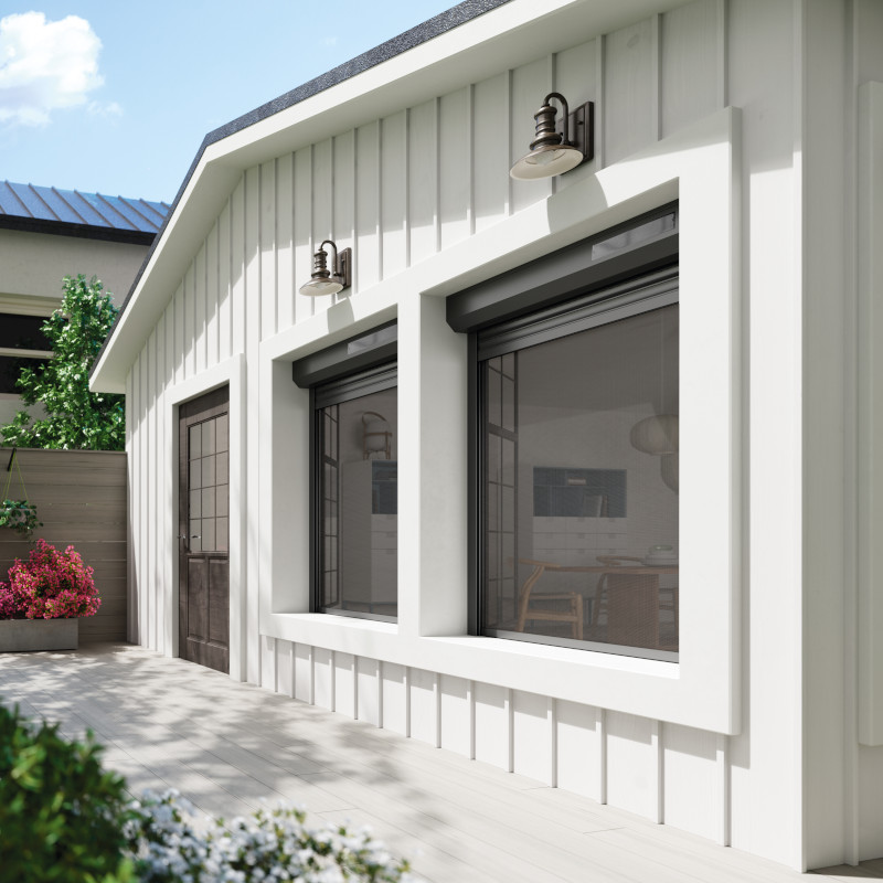 Photo d'ambiance de volets roulants avec moustiquaires et panneau solaire Volets roulants solaires avec moustiquaires intégrées anthracite sur une maison