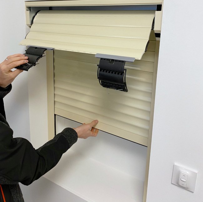 Situées sur la partie inférieure du tablier, vous remarquerez deux petites butées d'arrêt, enlevez-les. Défaite des butées d'arrêt de la lame finale